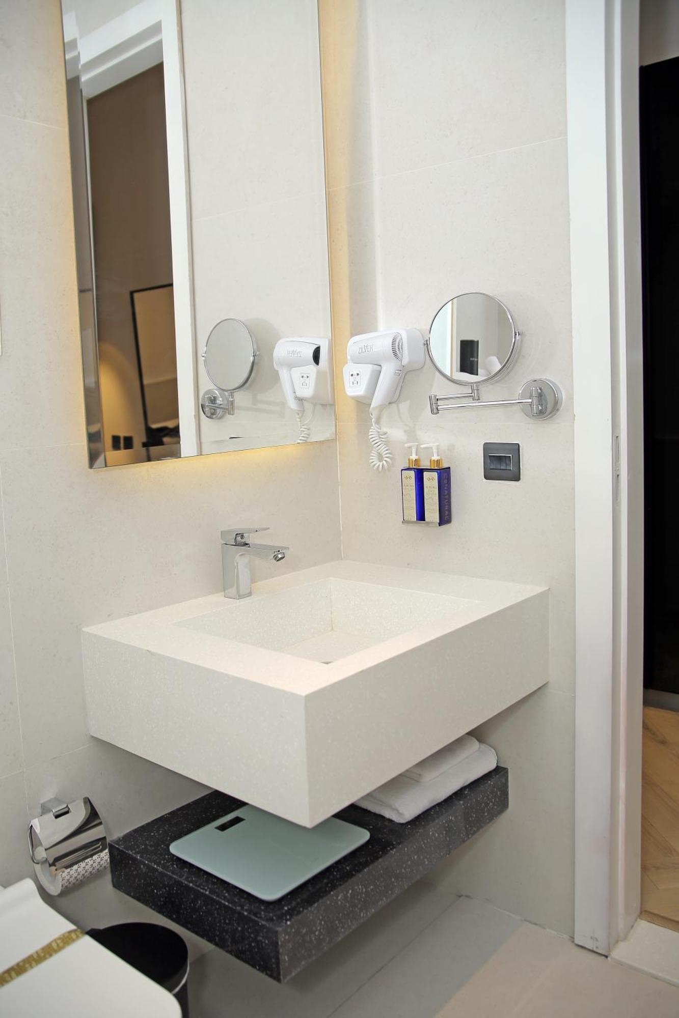 Ambiance Boutique Art Hotel Lahore Ruang foto A wall mounted hair dryer in a hotel bathroom